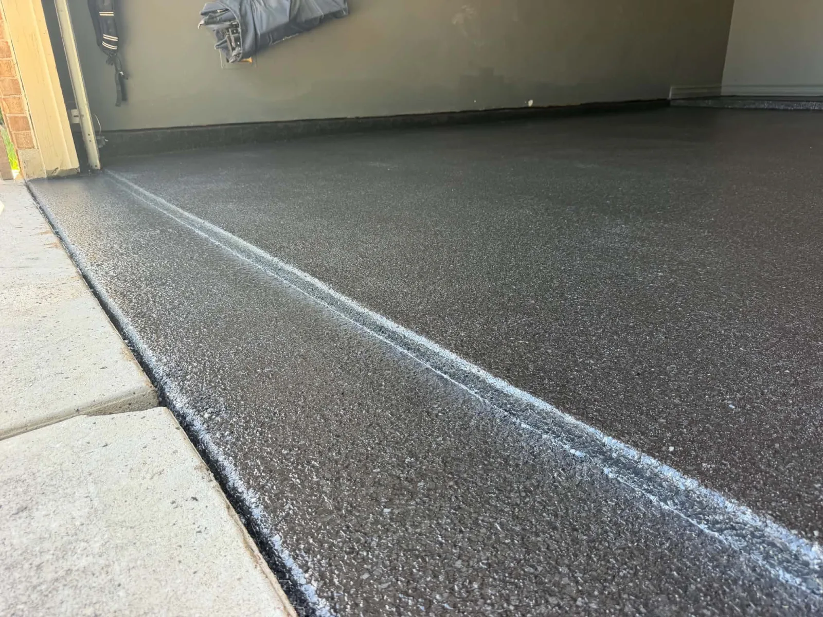 Black flake coating at a garage floor threshold