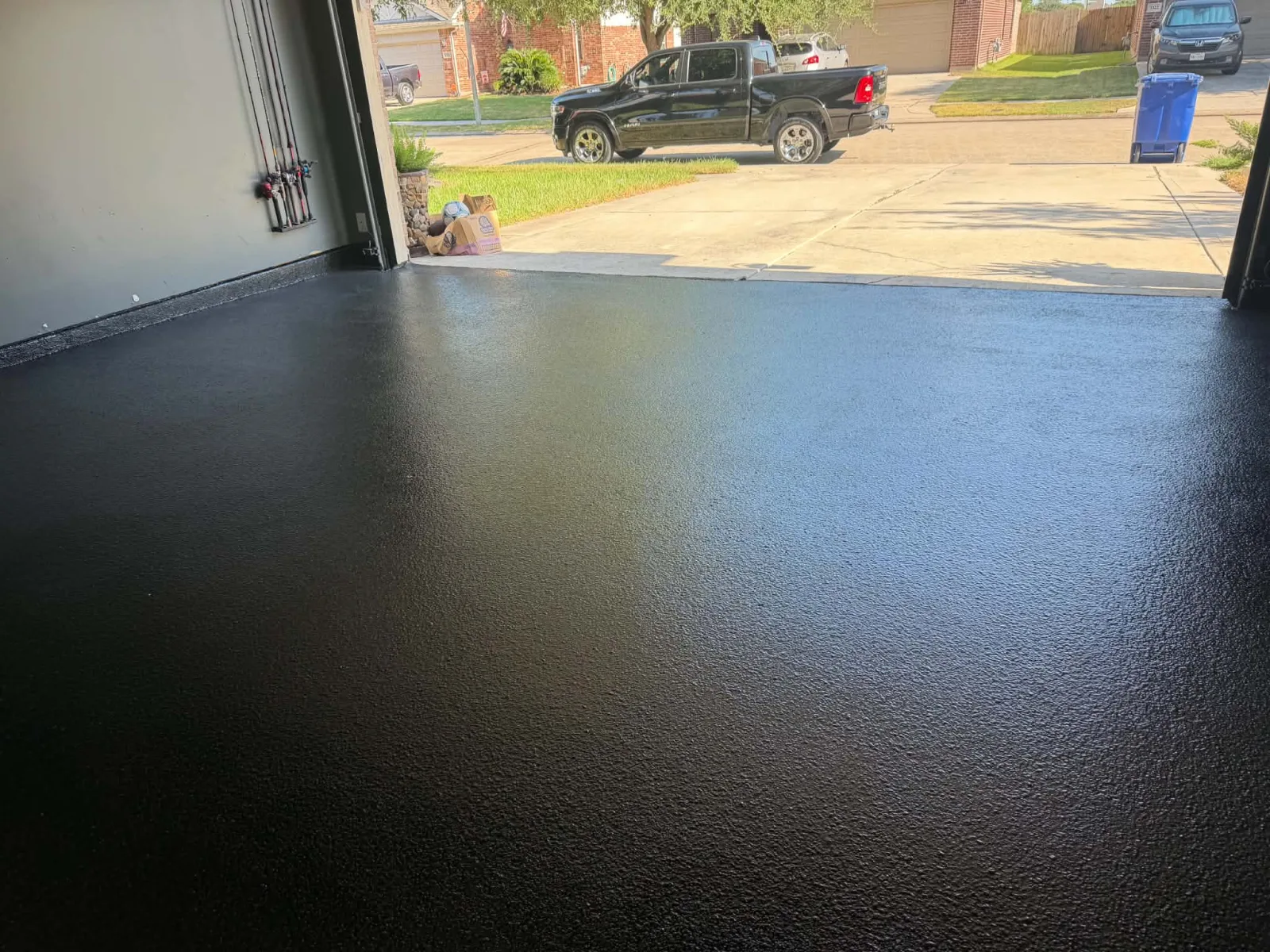 Completed black flake garage floor coating viewed across the full garage